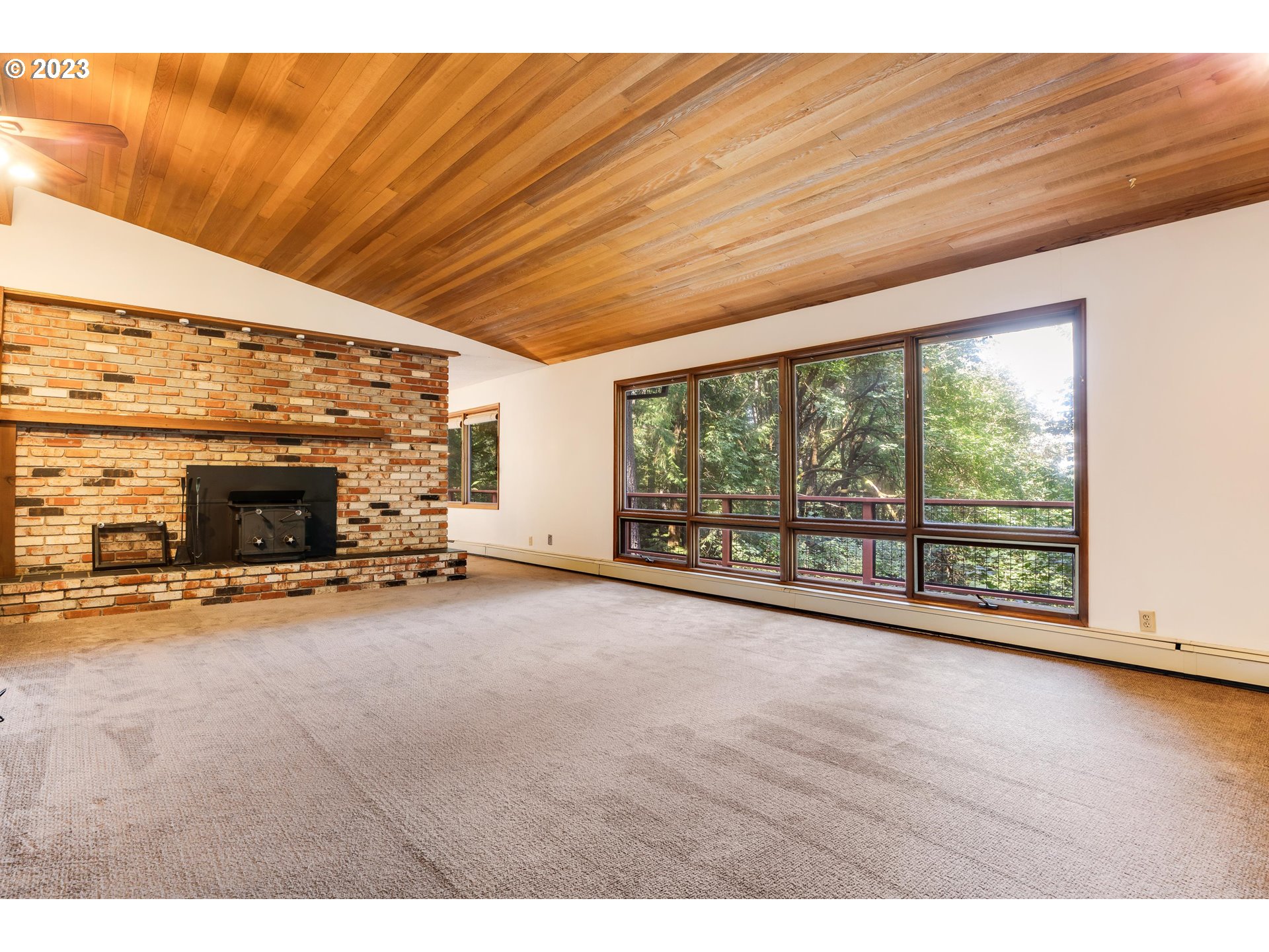 15729 Northwest Sheltered Nook Road Portland, OR 97231 - Photo 23 of 44 a view of an empty room with wooden floor and a fireplace