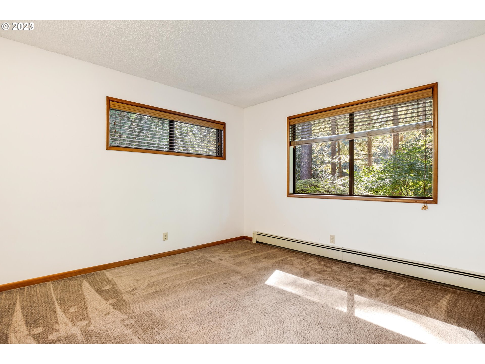 15729 Northwest Sheltered Nook Road Portland, OR 97231 - Photo 30 of 44 an empty room with wooden floor and windows