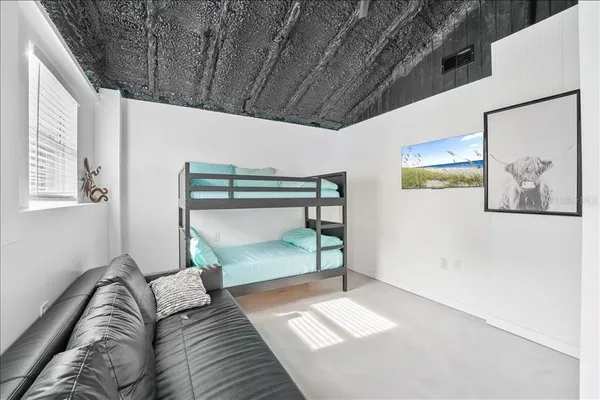 a bedroom with a bed and a painting on the wall