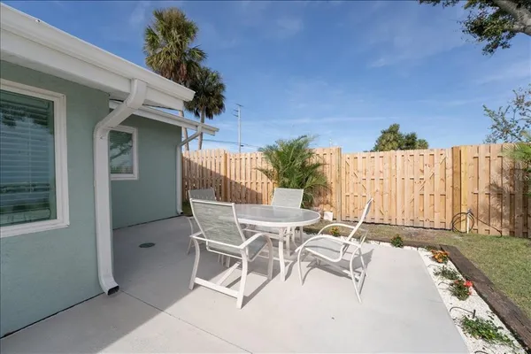 a view of a patio with table and chairs and potted plants