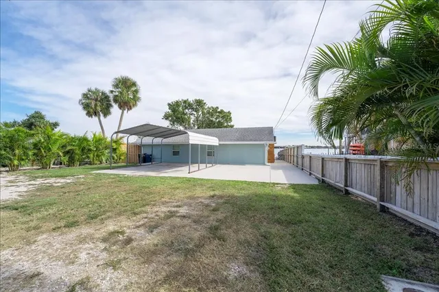 a view of a backyard with a patio and swimming pool