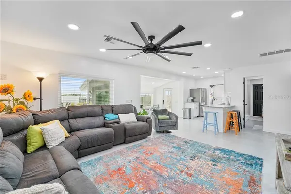 a living room with furniture and a view of kitchen