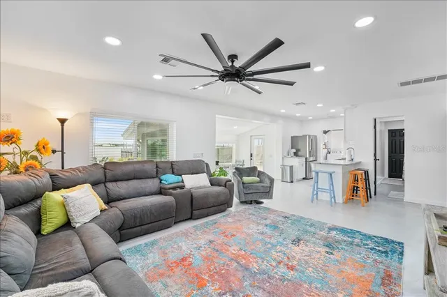 a living room with furniture and a view of kitchen