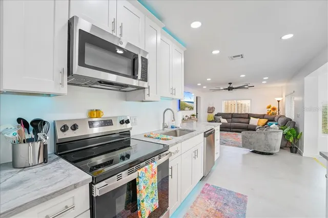 a kitchen with stainless steel appliances kitchen island granite countertop a sink and a stove