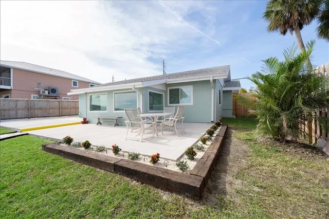 a roof deck with table and chairs and wooden fence