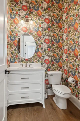 a bathroom with a granite countertop toilet a sink and a mirror