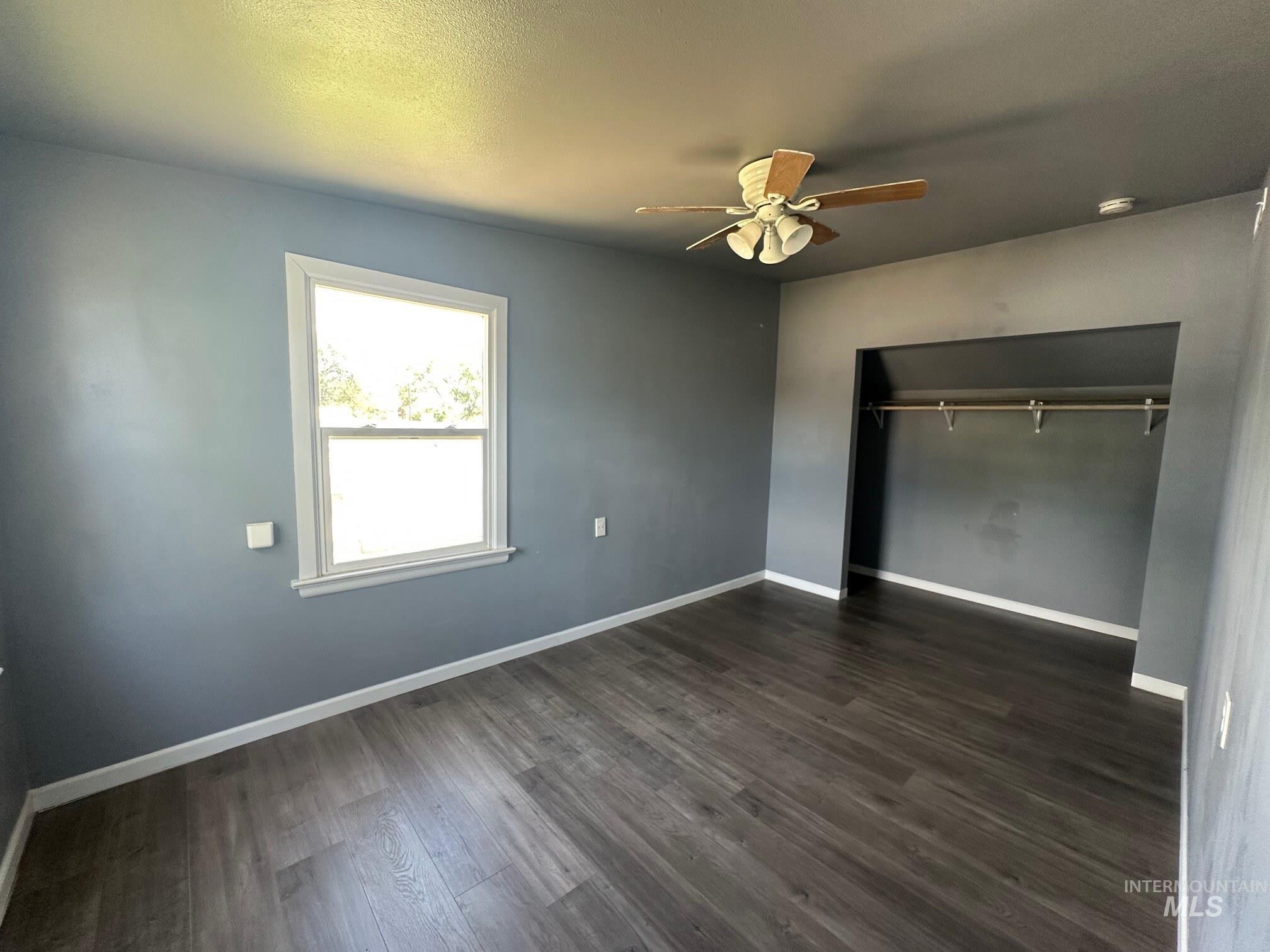 787 Southwest 3rd Street Ontario, OR 97914 - Photo 12 of 22 Unfurnished bedroom featuring dark wood finished floors and a ceiling fan