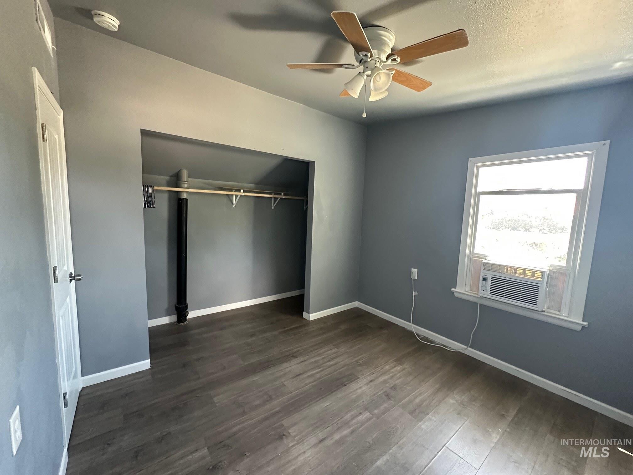 787 Southwest 3rd Street Ontario, OR 97914 - Photo 13 of 22 Unfurnished bedroom with dark wood-style flooring, a closet, ceiling fan, and cooling unit