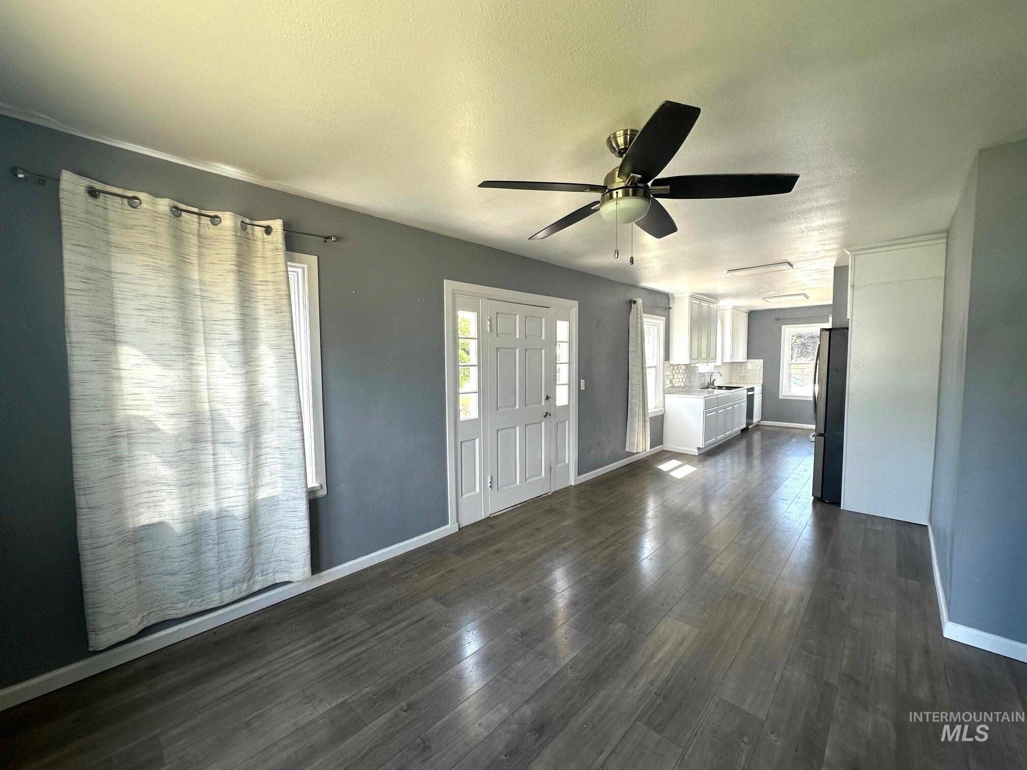 787 Southwest 3rd Street Ontario, OR 97914 - Photo 7 of 22 Unfurnished living room with dark wood-style floors, a textured ceiling, and ceiling fan