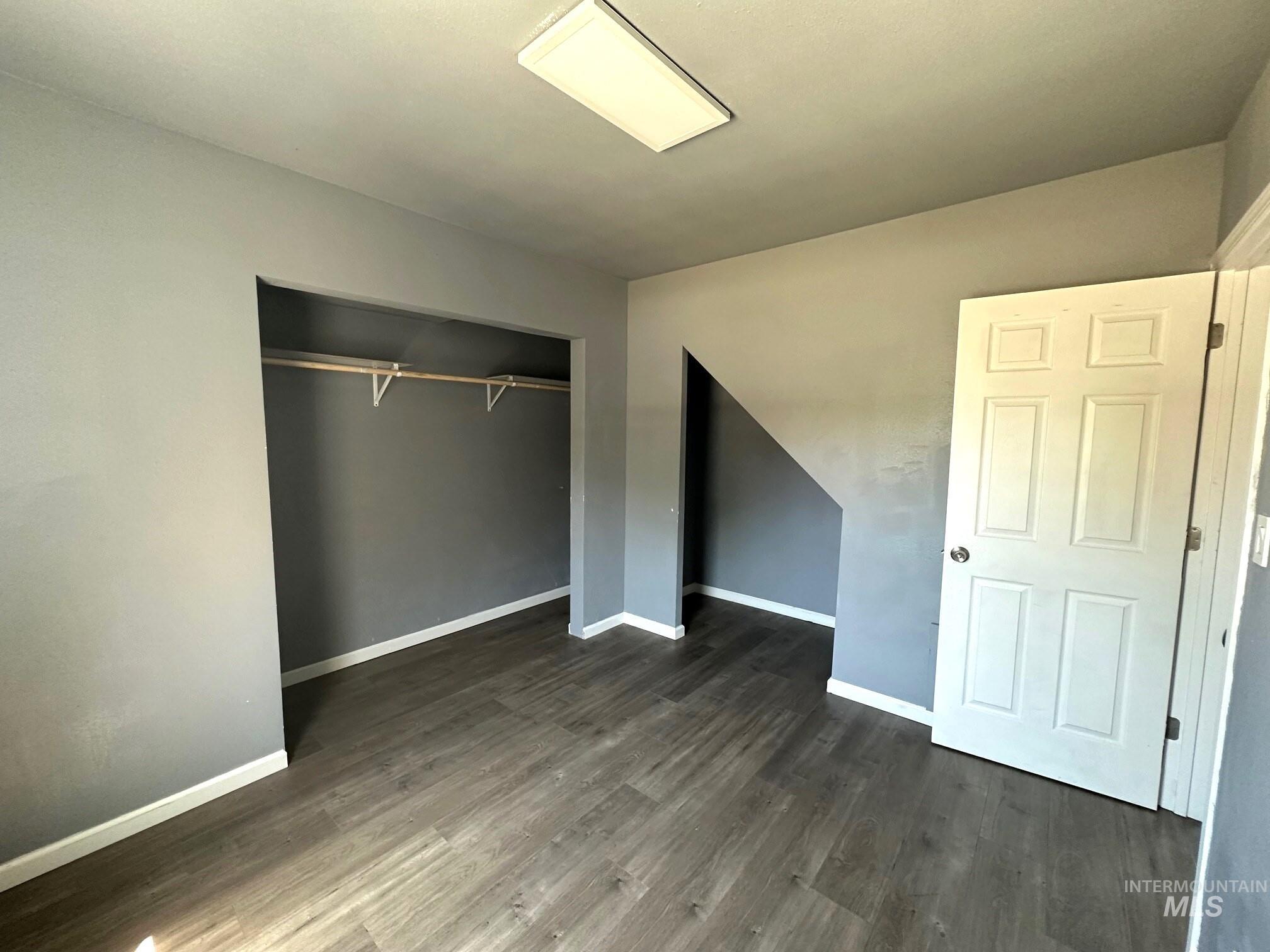 787 Southwest 3rd Street Ontario, OR 97914 - Photo 9 of 22 Unfurnished bedroom featuring dark wood-style flooring and a closet