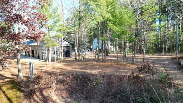 a backyard of a house with large tree and wooden fence