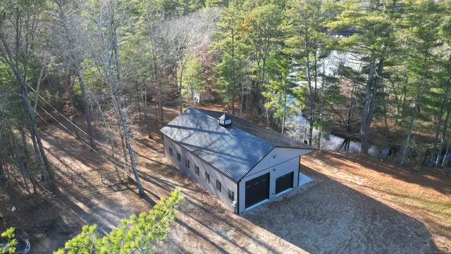 a backyard of a house with large trees and outdoor seating