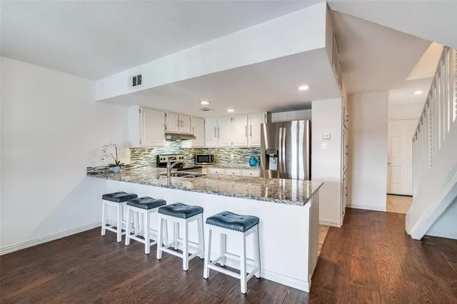 a kitchen with stainless steel appliances granite countertop a stove a sink and a refrigerator