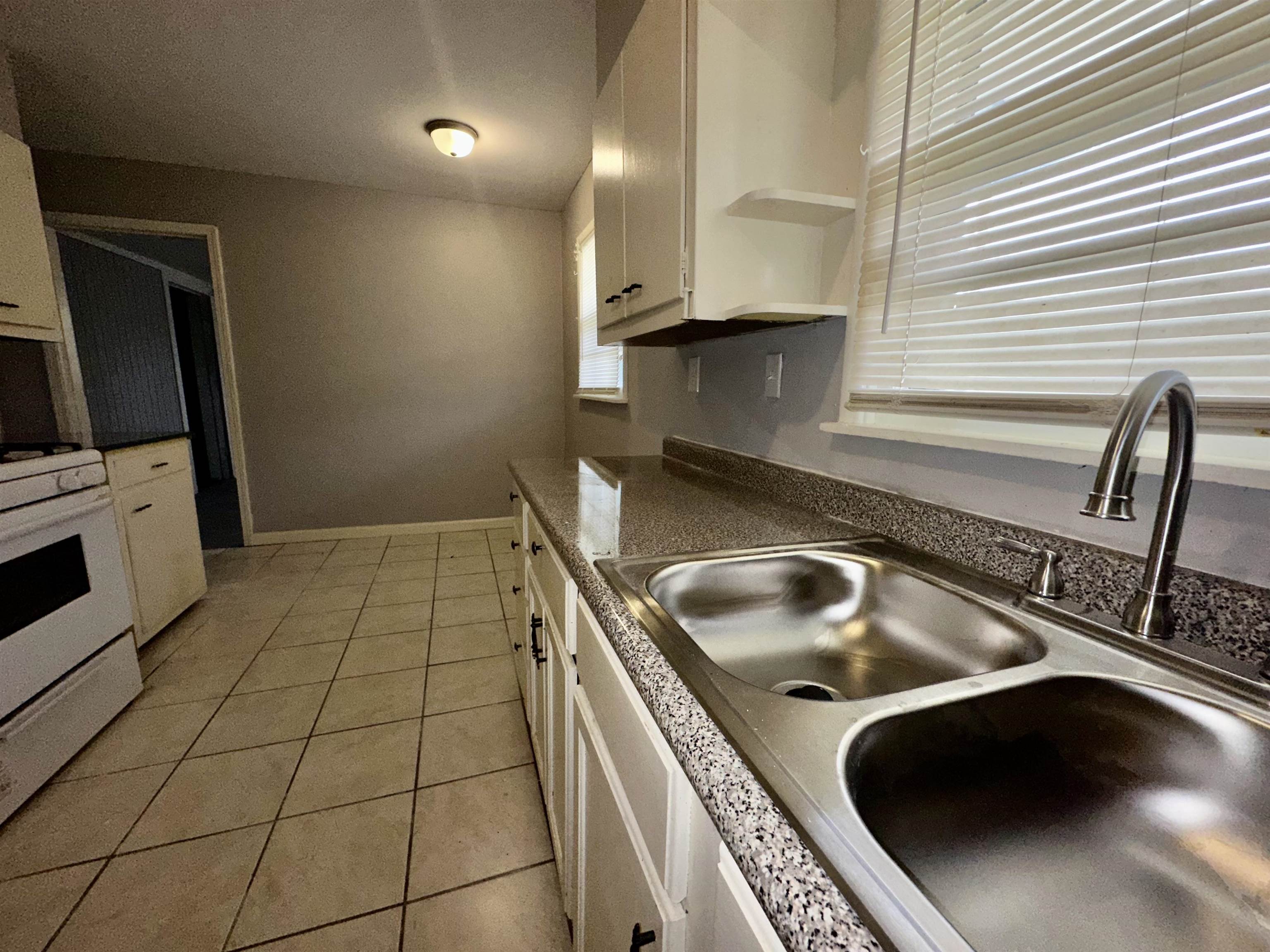 4277 Neely Road Memphis, TN 38109 - Photo 4 of 19 a kitchen with a sink a stove and cabinets