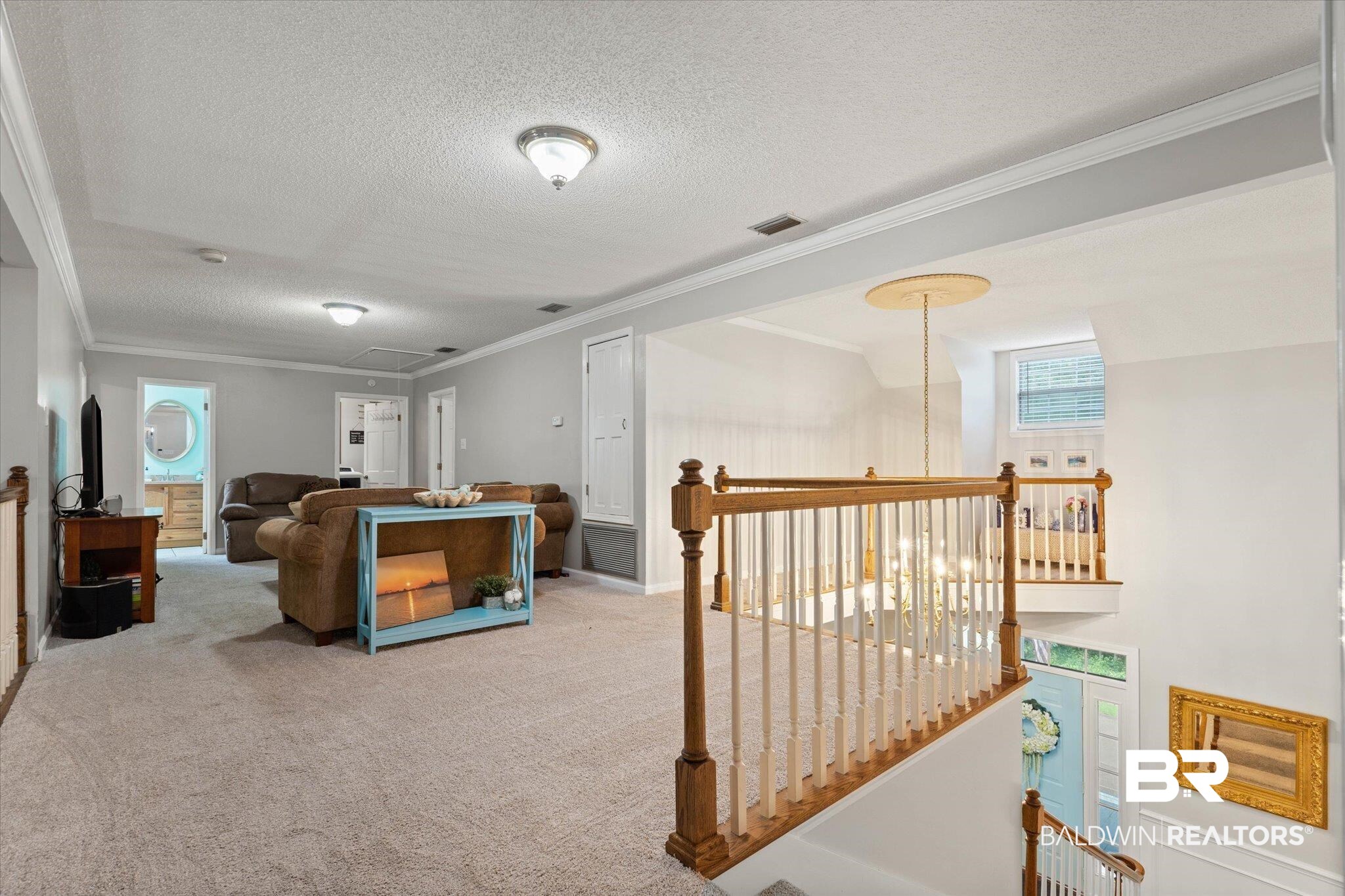 2300 Radcliff Road Saraland, AL 36571 - Photo 18 of 56 Living room featuring a textured ceiling, carpet flooring, attic access, and crown molding