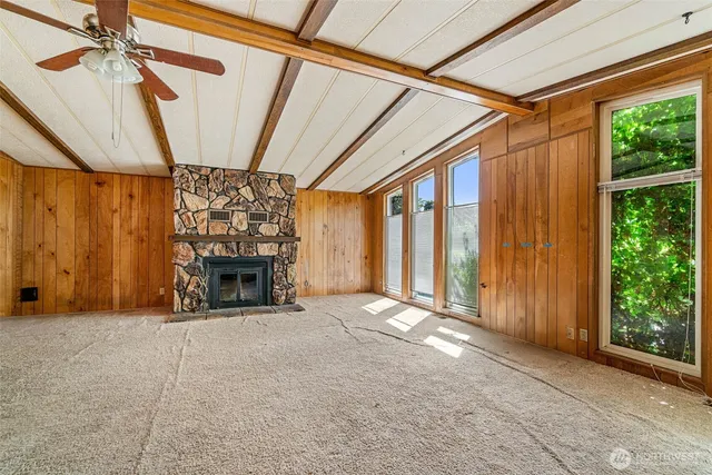 a view of an empty room with a fireplace and a window