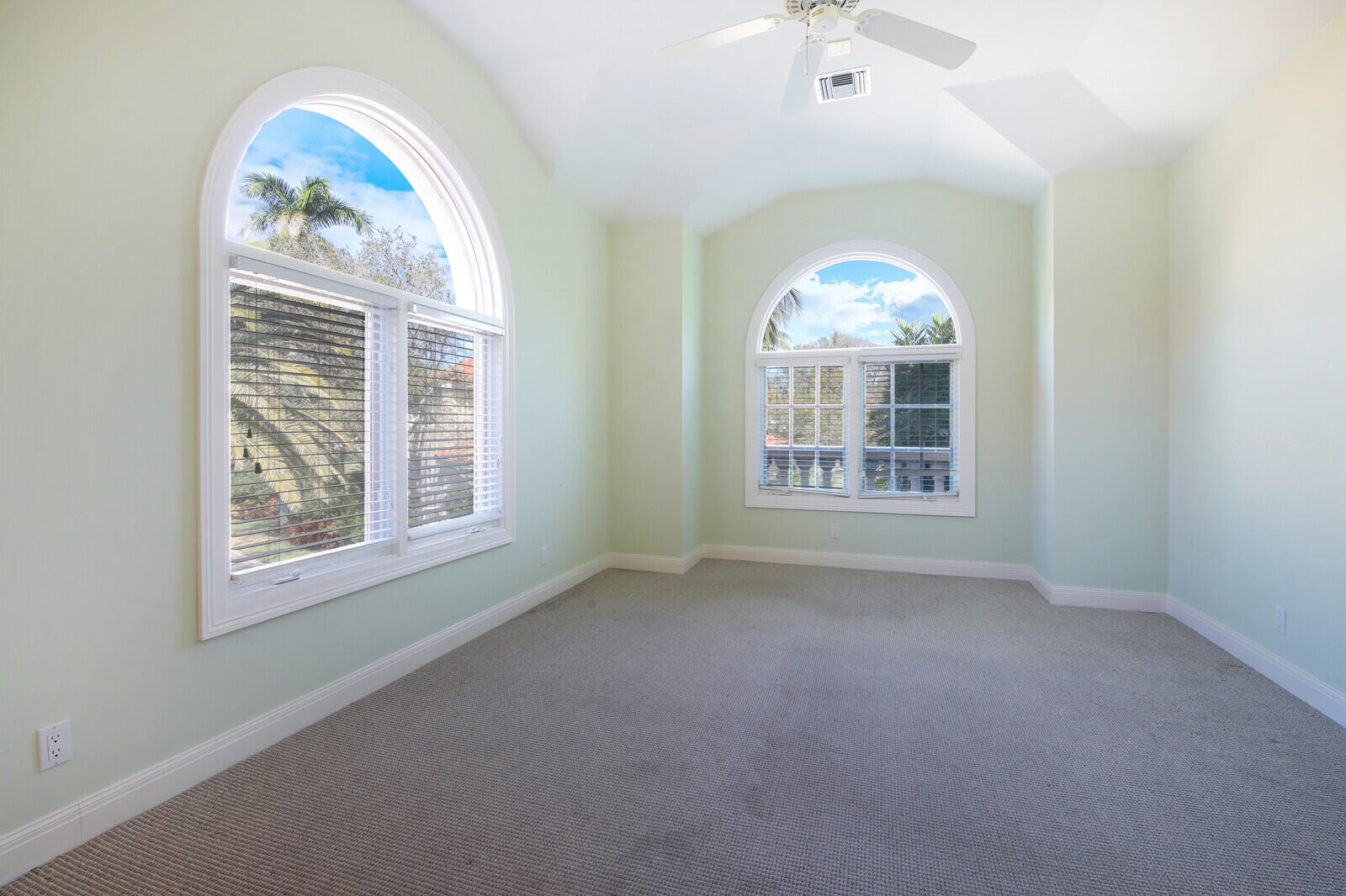 3370 Bridgegate Drive Jupiter, FL 33477 - Photo 38 of 55 an empty room with windows curtains and a chandelier