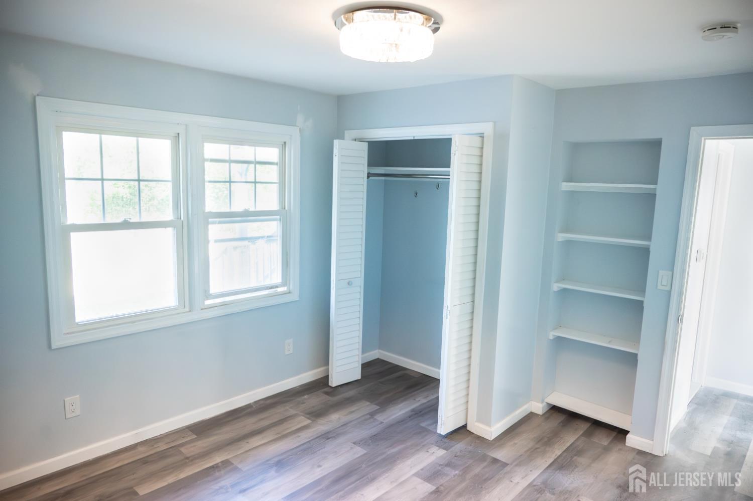 101 Perry Street Keyport, NJ 07735 - Photo 8 of 15 an empty room with wooden floor closet and windows