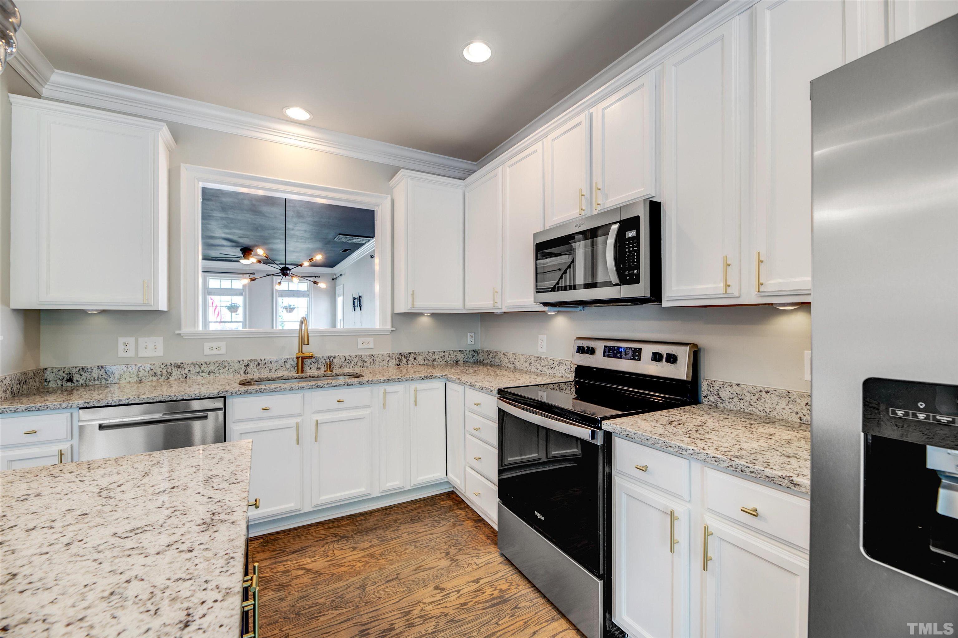 7736 ACC Boulevard Raleigh, NC 27617 - Photo 12 of 37 a kitchen with stainless steel appliances granite countertop a stove top oven a sink dishwasher and microwave oven