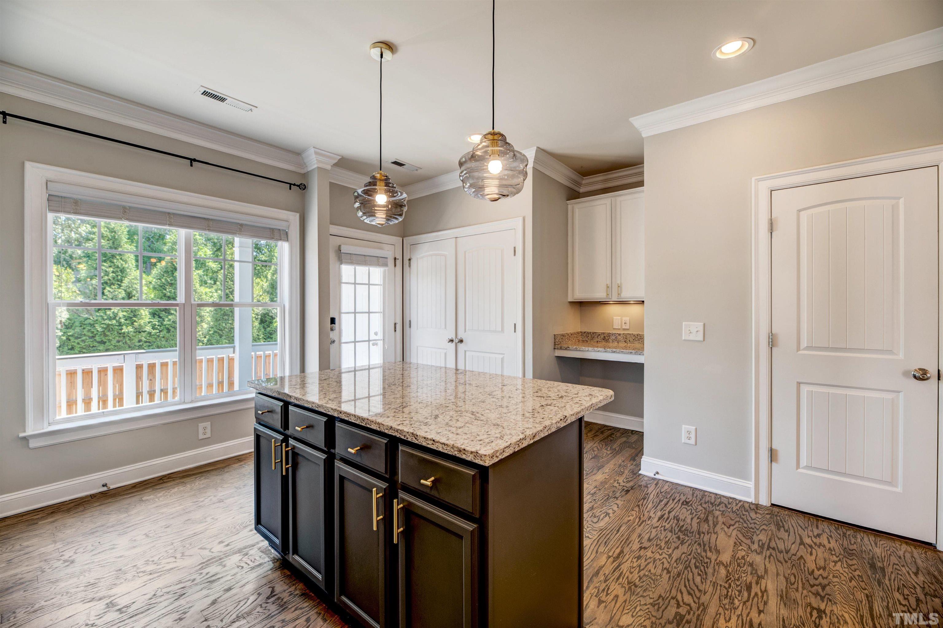 7736 ACC Boulevard Raleigh, NC 27617 - Photo 13 of 37 a kitchen with kitchen island granite countertop a stove a sink and a window