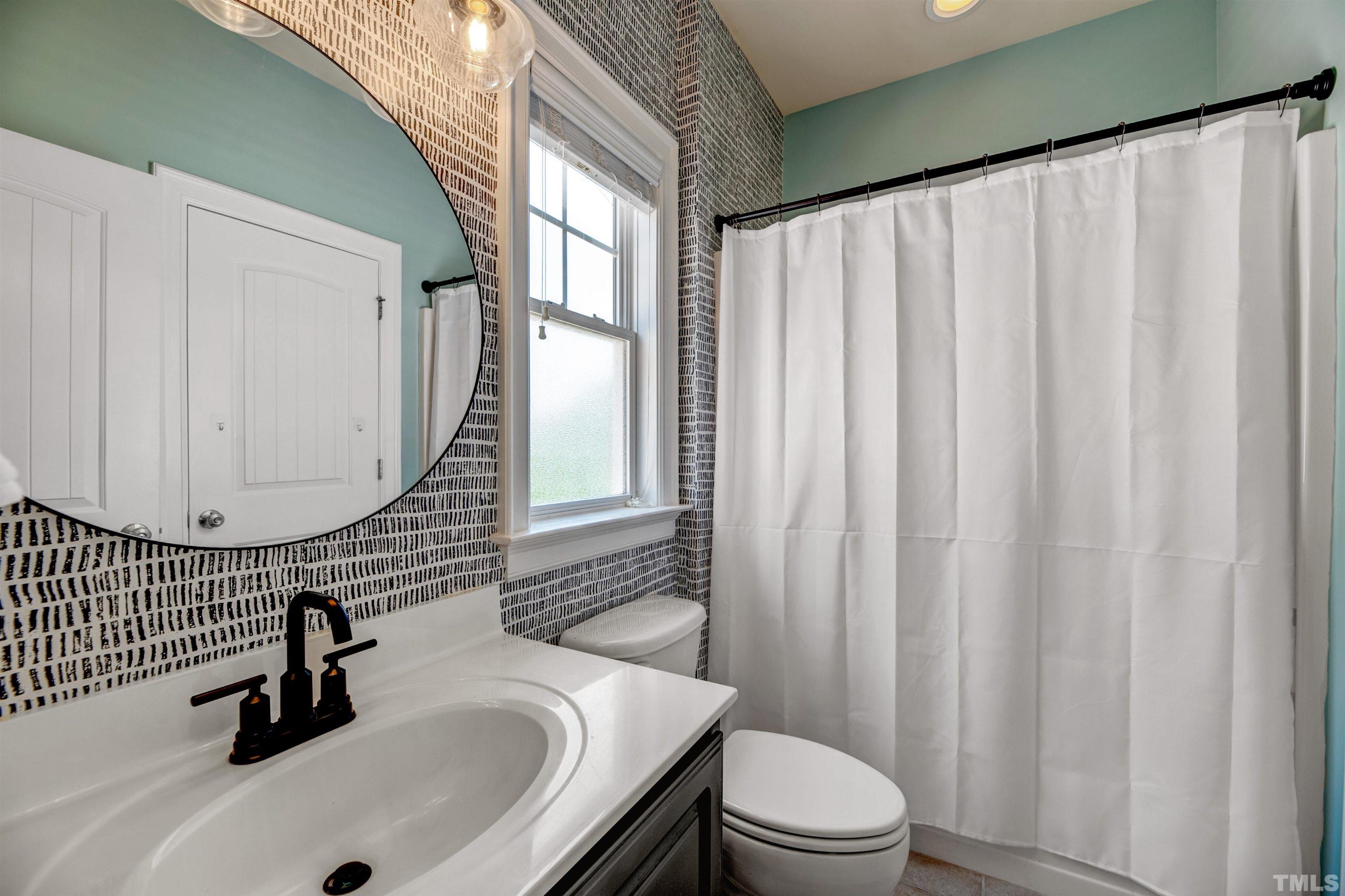 7736 ACC Boulevard Raleigh, NC 27617 - Photo 20 of 37 a bathroom with a sink a toilet and a mirror