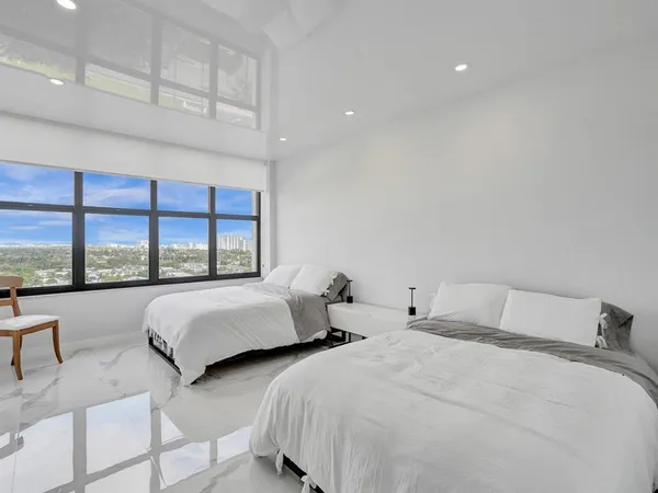 a bedroom with two beds and a large window