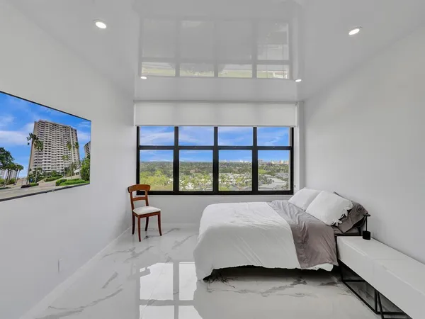 a spacious bedroom with a bed and a large window