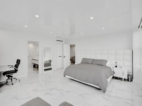 a spacious bedroom with a bed a table and chair