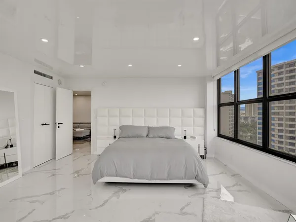 a bedroom with a large bed and a large window