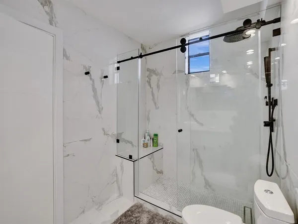 a bathroom with a shower toilet and sink