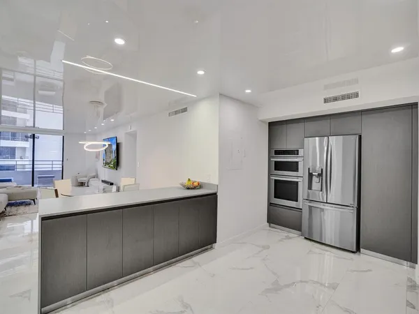 a kitchen with kitchen island stainless steel appliances a sink stove and refrigerator