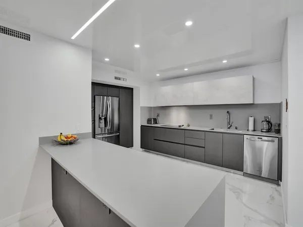 a kitchen with stainless steel appliances a sink stove and refrigerator