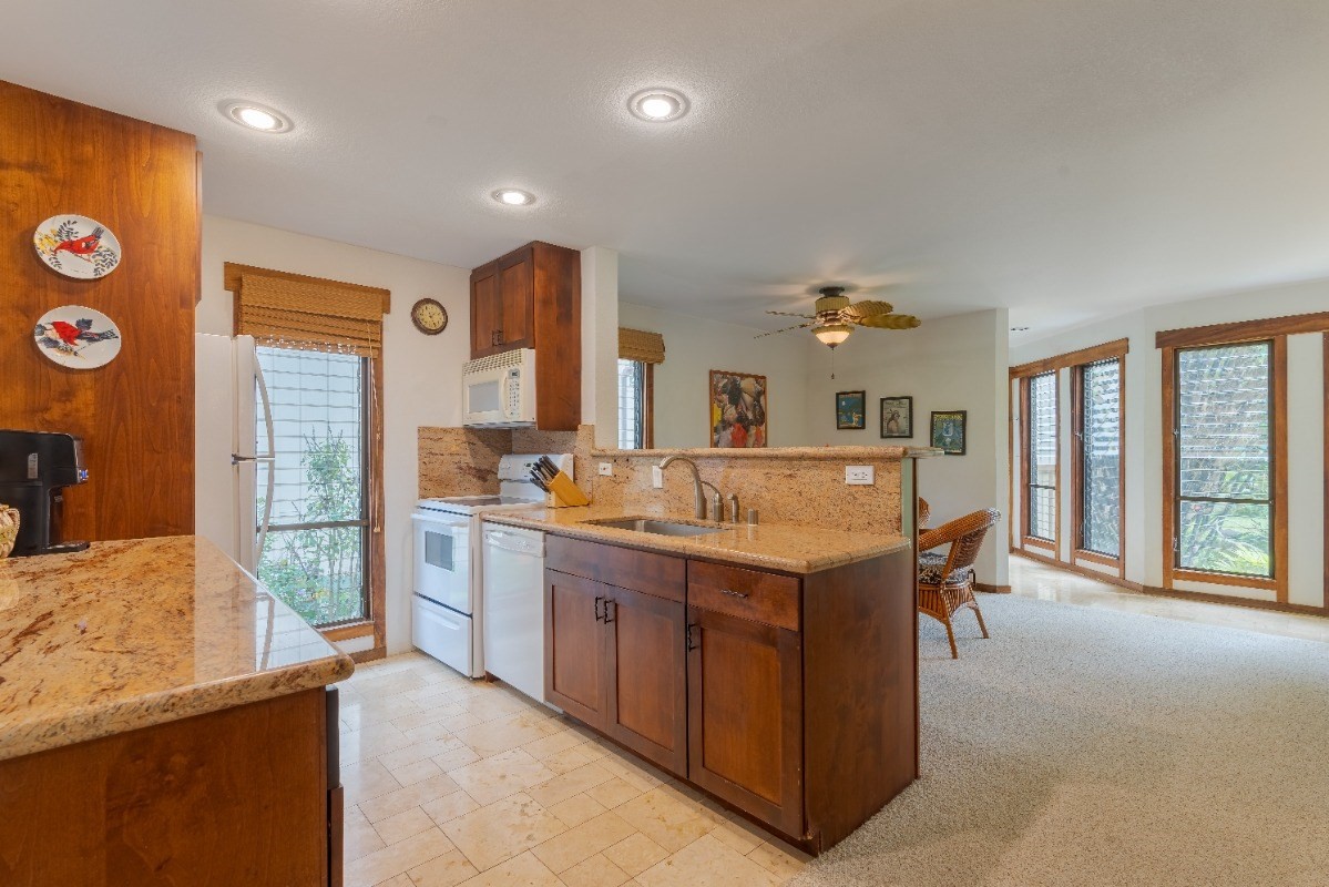 2721 Poipu Road, Unit 420 Koloa, HI 96756 - Photo 3 of 26 a large kitchen with granite countertop a sink and a refrigerator