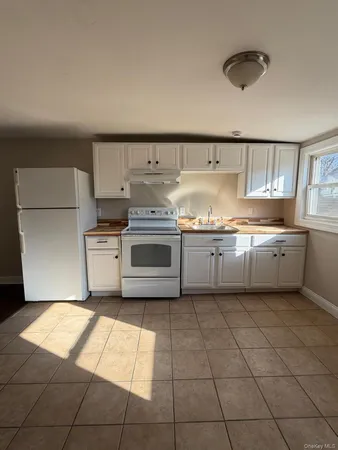 a kitchen with a stove top oven and cabinets