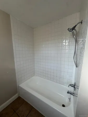 a white bath tub sitting next to a white sink and vanity