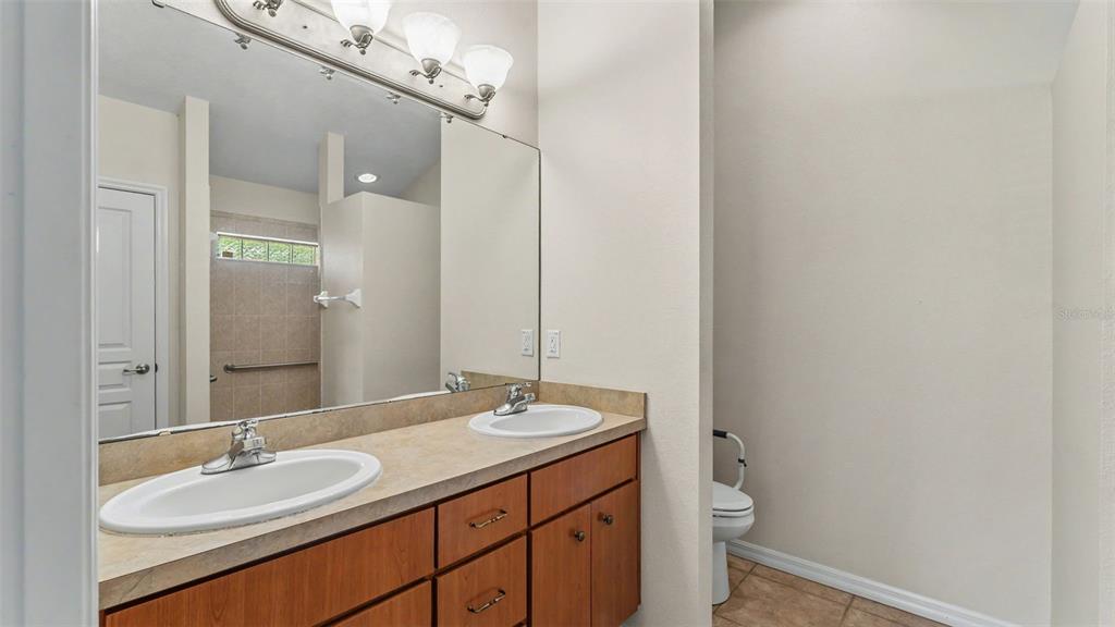 8525 North Campbell Road Lakeland, FL 33810 - Photo 19 of 45 a bathroom with a granite countertop sink a toilet and a mirror