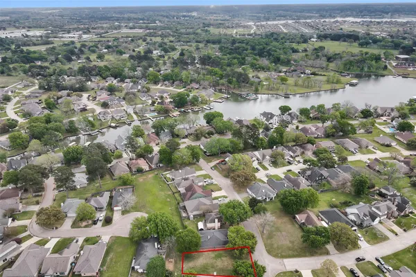 an aerial view of residential houses with outdoor space and lake view