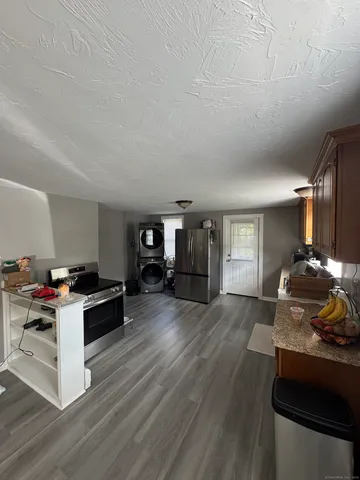a kitchen with granite countertop a stove and a wooden floors