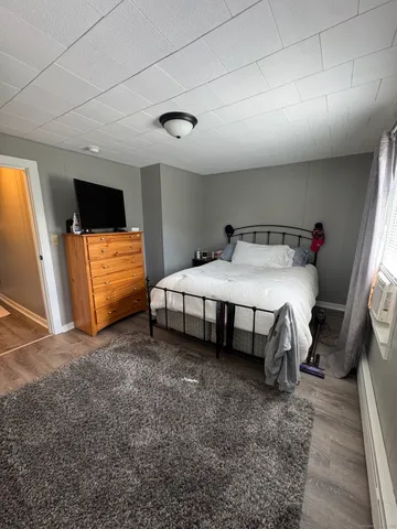 a bedroom with a bed and a flat screen tv