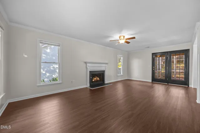 an empty room with wooden floor and fireplace