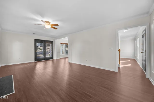 a view of an empty room with wooden floor fireplace and a window