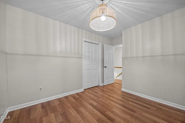 a view of empty room with window and chandelier fan