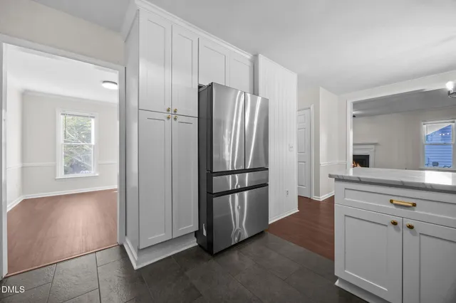 a kitchen with white cabinets appliances a sink and a window
