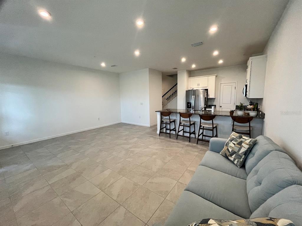 4208 Sadler Road Apopka, FL 32712 - Photo 5 of 7 a living room with furniture and a white wall with potted plants