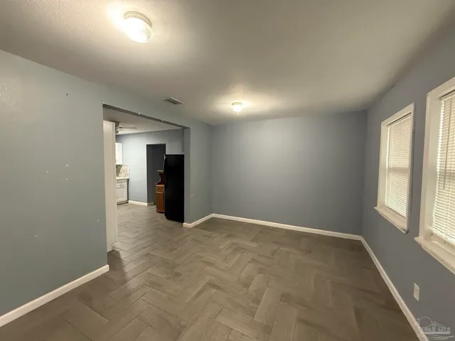 an empty room with closet and windows