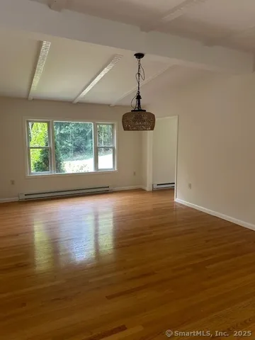 a view of a room with wooden floor and window