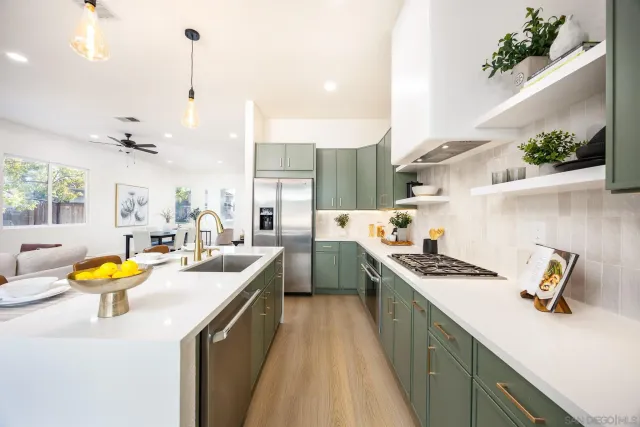 a kitchen that has a lot of cabinets a sink and a wooden floor