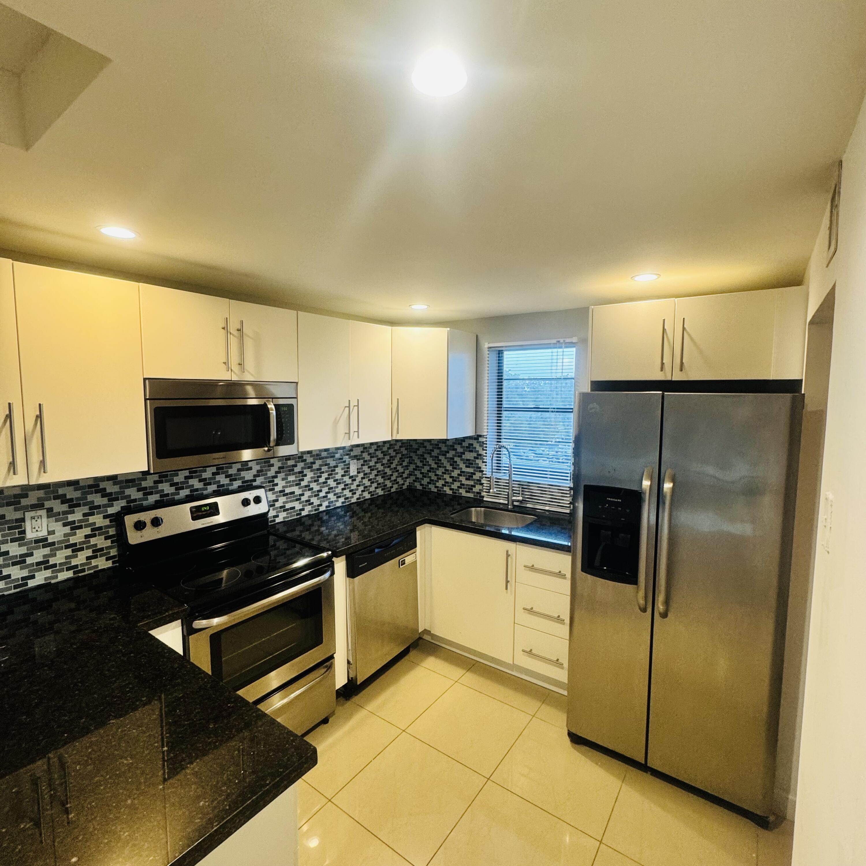 9235 Southwest 8th Street, Unit 503 Boca Raton, FL 33428 - Photo 2 of 17 a kitchen with stainless steel appliances granite countertop a stove a refrigerator and a sink