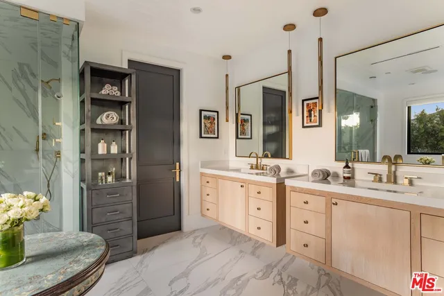 a spacious bathroom with double vanity sinks a shower a vanity and a mirror