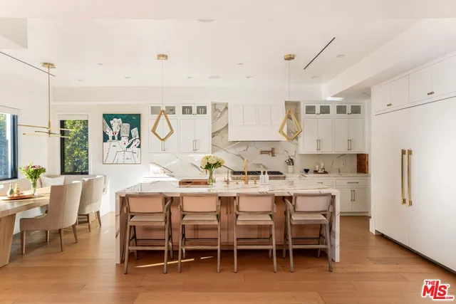 a dining area with stainless steel appliances kitchen island granite countertop furniture and a refrigerator